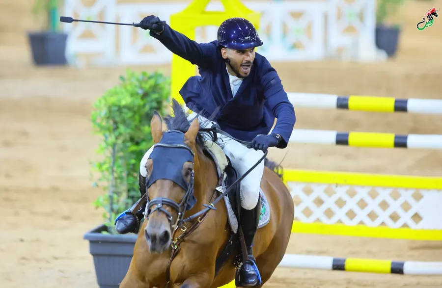 Rider celebrating with his arm raised after a clear round