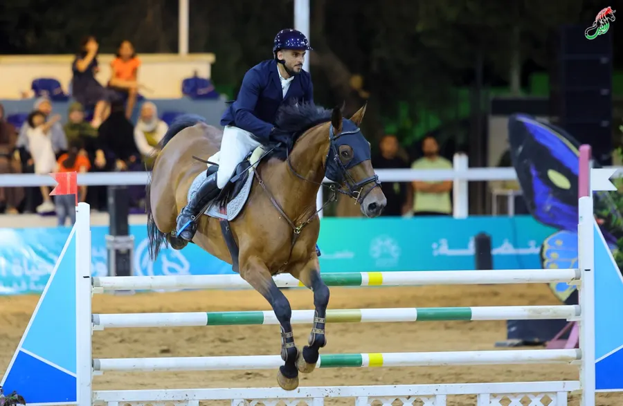 Leith Jumping horse and rider clearing a fence in front of the crowd