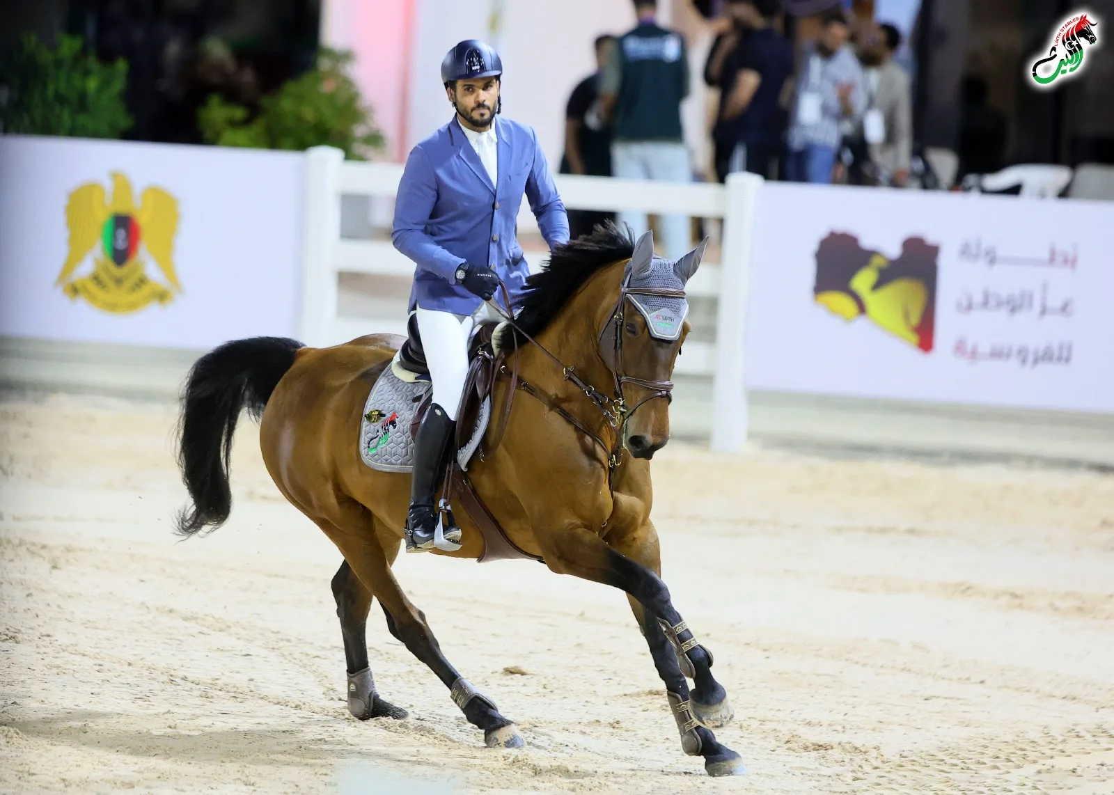Show jumping before the Libyan crest